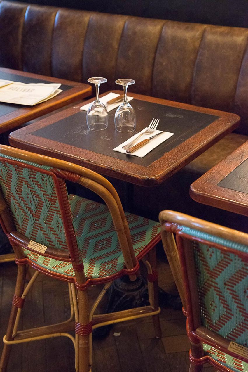 Intérieur du Café Bolivar à Paris avec ses chaises en cannage et sa banquette en cuir. Décoration faite par le Studio Emma Roux
