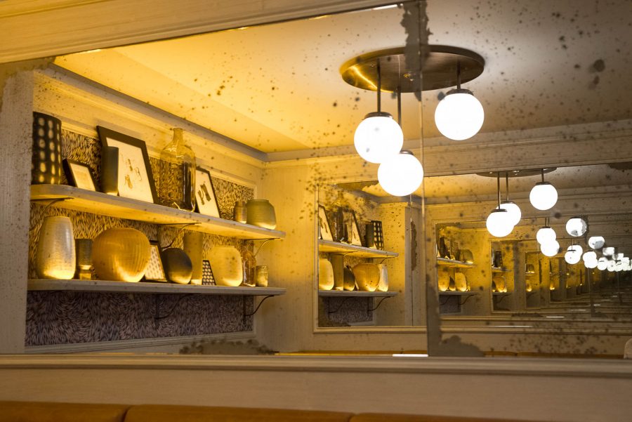 Miroir du Café Mademoiselle de Paris avec ses luminaires suspendus et ses étagères.