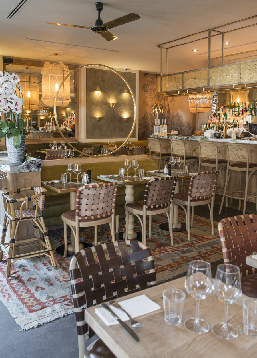 Restaurant Le Murillo de Paris - Décoration Emma Roux. Chaises tressées de cuir, banquette en velour, tapis kilim, luminaire en laiton.