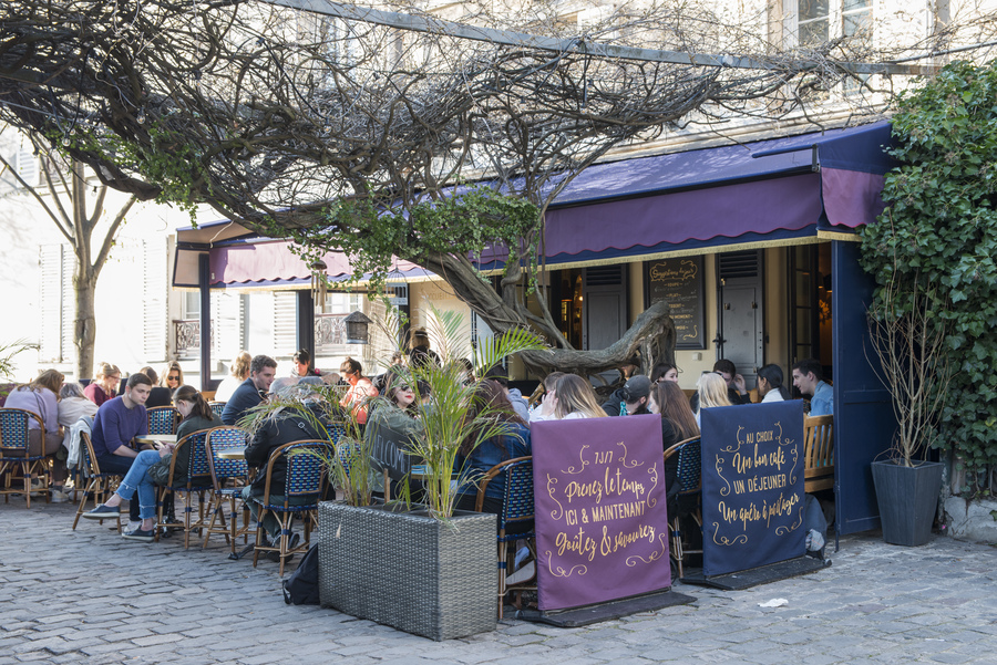 Restaurant Chez Plumeau à Montmartre - Décoration Studio Emma Roux. Panneaux extérieur, signalétique, chaises en cannage et store coloré.