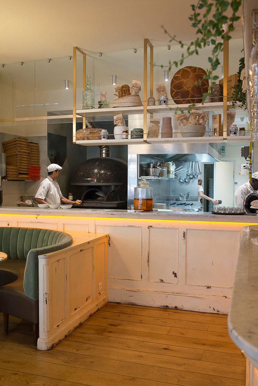 Intérieur de la pizzeria Simonetta de Paris. Comptoir en bois blanc vieilli, cuisine apparente. Décoration par le Studio Emma Roux