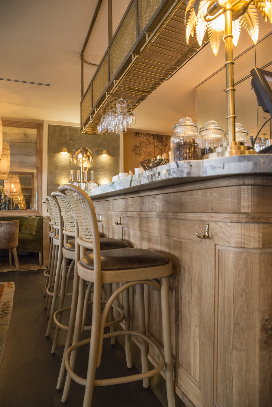 Restaurant Le Murillo de Paris - Décoration Emma Roux. Chaises en cannage, marbre, bois brut, luminaire en laiton.