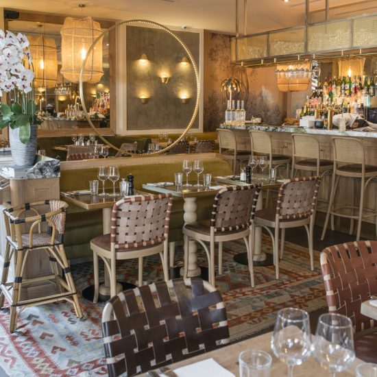 Restaurant Le Murillo de Paris - Décoration Emma Roux. Chaises tressées de cuir, banquette en velour, tapis kilim, luminaire en laiton.