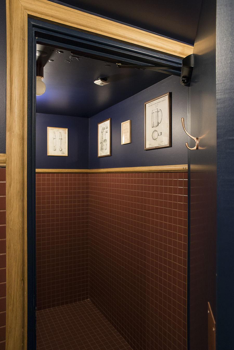 Relooking décoratif par le Studio Emma Roux à Paris, toilettes bleu marine et carrelage carré, meuble bois